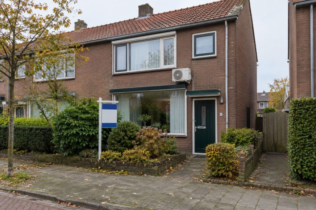 Te koop staande Nederlandse familie woning met airco buitenunit boven de tuinraam